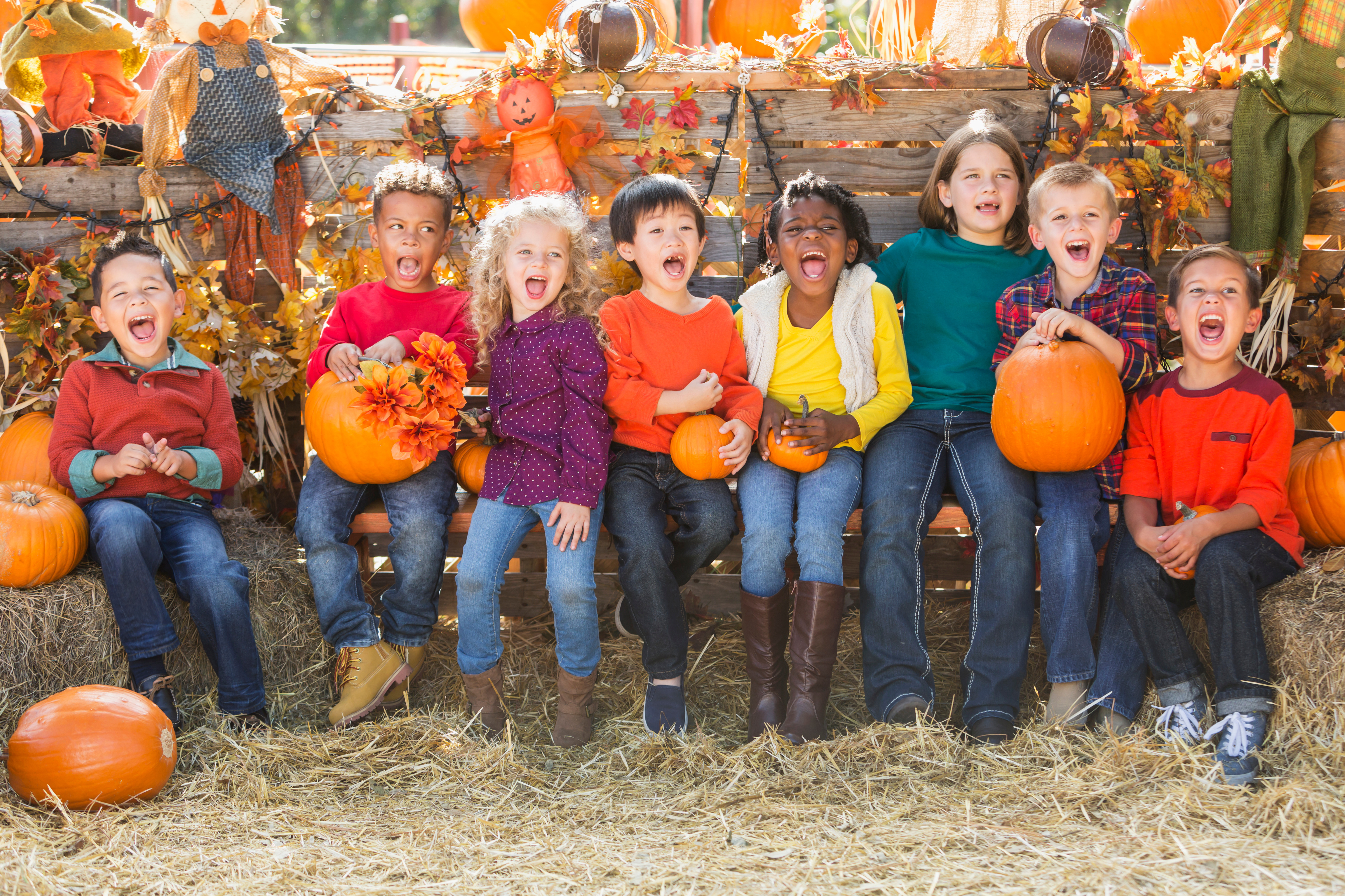 Multi-ethnic children with pumpkins at fall festival